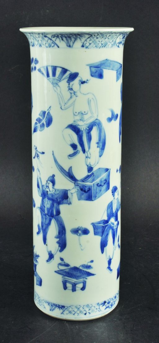 A 19TH CENTURY CHINESE BLUE & WHITE PORCELAIN VASE, the: A 19TH CENTURY CHINESE BLUE & WHITE PORCELAIN VASE, the sides of the cylindrical body painted with a variety of street performers, the base with a four-character Kangxi mark, 12.2in high. £150-250