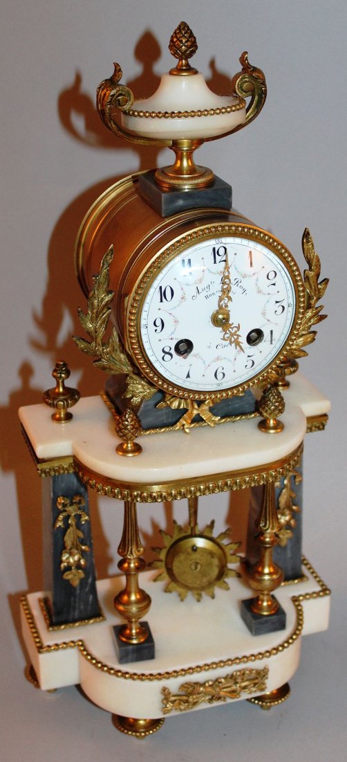 A 19TH CENTURY FRENCH ORMOLU AND WHITE MARBLE CLOCK: A 19TH CENTURY FRENCH ORMOLU AND WHITE MARBLE CLOCK with eight day drum movement by Aug. Le Roy, Caen, with urn finial and column supports on astragal base. 16ins high. £500-600.