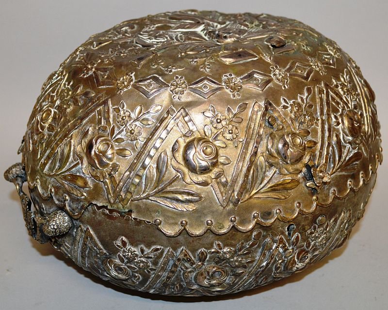 A RARE TURKISH 18TH CENTURY OVAL WEDDING BOX with: A RARE TURKISH 18TH CENTURY OVAL WEDDING BOX with repousse decoration, flowers and motifs. Mark leaping animal and crescent. 11ins wide. £500-1000.