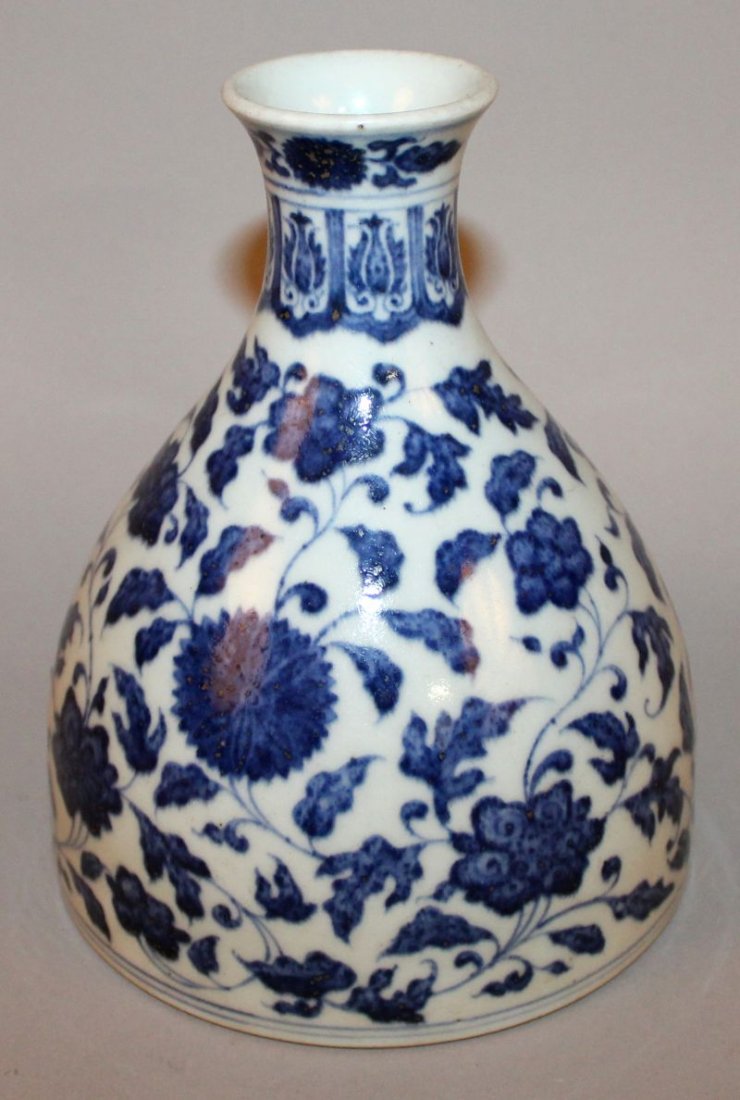 A CHINESE MING-STYLE BLUE & WHITE PORCELAIN VASE, of: A CHINESE MING-STYLE BLUE & WHITE PORCELAIN VASE, of unusual form, decorated with formal scrolling leaf-stemmed flower heads, the base with a Qianlong seal mark, 6.5in high & 5.25in diameter at base.