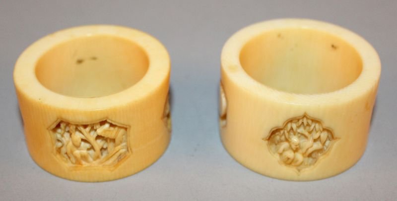 A NEAR PAIR OF 19TH CENTURY CHINESE CANTON IVORY NAPKIN: A NEAR PAIR OF 19TH CENTURY CHINESE CANTON IVORY NAPKIN RINGS, 1.8in & 1.9in diameter.