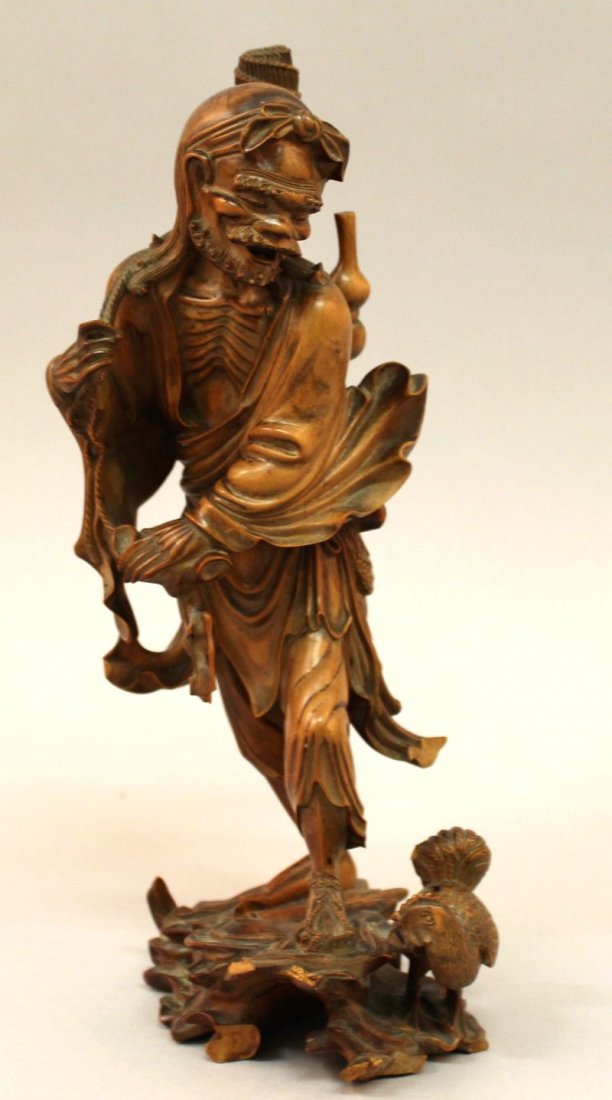 A FINE QUALITY 19TH CENTURY CHINESE WOOD CARVING OF LI: A FINE QUALITY 19TH CENTURY CHINESE WOOD CARVING OF LI TIGUAI, with his gourd, standing on rockwork, his features finely carved, 9.1in high.