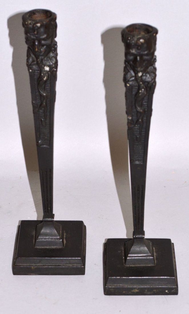 A PAIR OF RUSSIAN CAST IRON CANDLESTICKS decorated with: A PAIR OF RUSSIAN CAST IRON CANDLESTICKS decorated with dragons on square bases. Mark in Cyrillic. 9.5ins high.