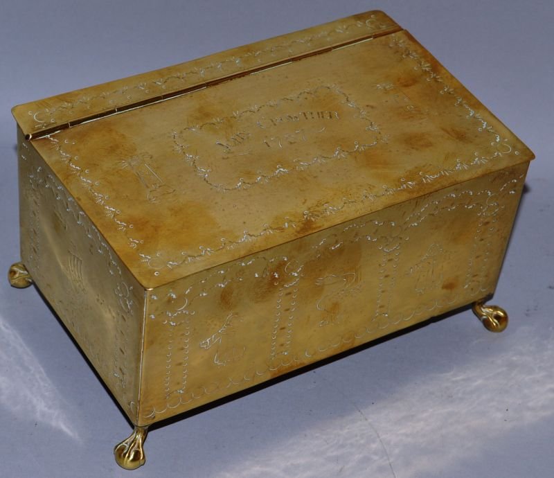 A GEORGE III ENGRAVED BRASS RECTANGULAR TOBACCO BOX AND: A GEORGE III ENGRAVED BRASS RECTANGULAR TOBACCO BOX AND COVER, engraved “JOHN CROWTHER 1787”, supported on bun feet. 7ins wide.