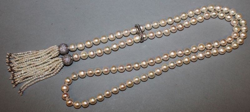 A LONG STRING OF FRESHWATER PEARLS, the ends with: A LONG STRING OF FRESHWATER PEARLS, the ends with tassels.