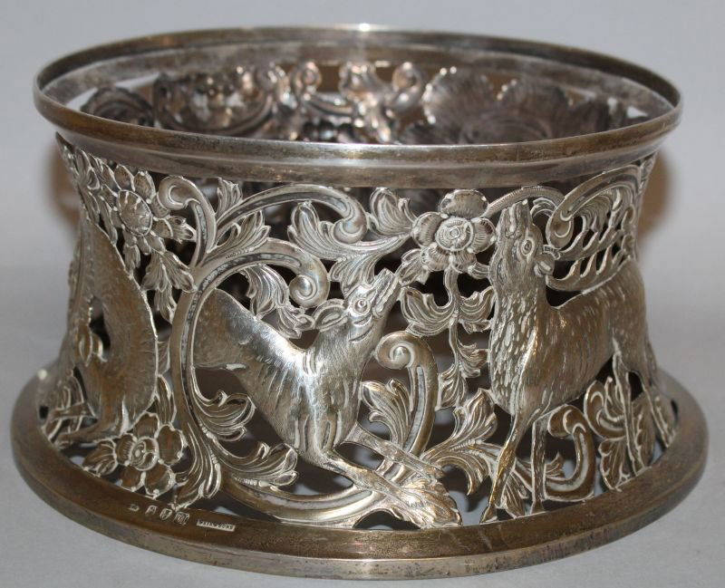 A GOOD IRISH GEORGE V PIERCED CIRCULAR DISH RING by: A GOOD IRISH GEORGE V PIERCED CIRCULAR DISH RING by WEIR & SONS, DUBLIN 1915, pierced with dogs, flowers and scrolls. 8.5ins diameter. Weight: 13ozs.