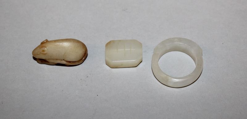 A CHINESE JADE-LIKE RING, together with two other small (1 of 4)
