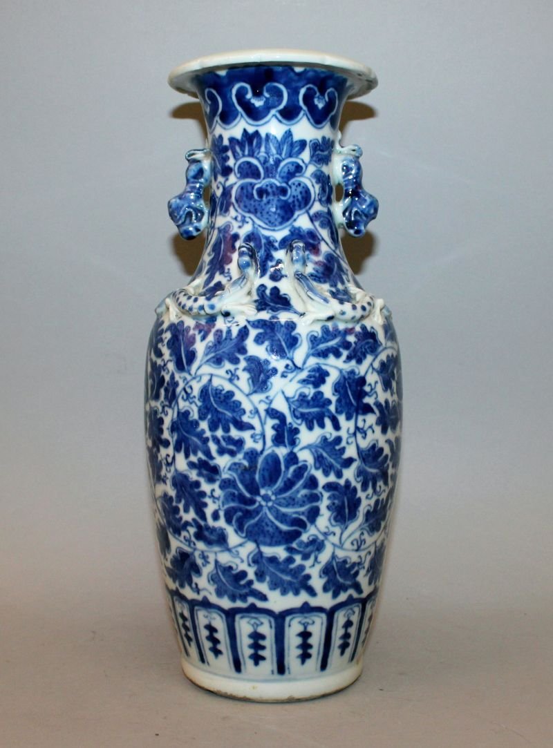 A 19TH CENTURY CHINESE BLUE & WHITE PORCELAIN VASE, the: A 19TH CENTURY CHINESE BLUE & WHITE PORCELAIN VASE, the sides painted with a formal design of scrolling leafage and flowerheads, 12.1in high.