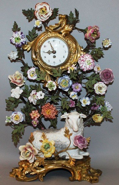 A SUPERB 18TH CENTURY FRENCH ORMOLU AND PORCELAIN: A SUPERB 18TH CENTURY FRENCH ORMOLU AND PORCELAIN MANTLE CLOCK with drum movement in a case with porcelain flowers, the base with a MEISSEN LAMB. 17ins high.