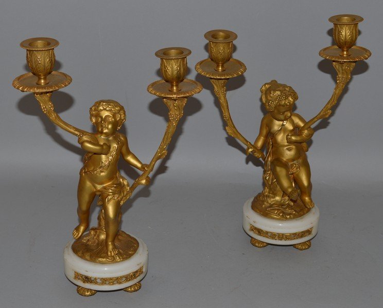 A VERY GOOD PAIR OF LOUIS XVI DESIGN ORMOLU AND WHITE: A VERY GOOD PAIR OF LOUIS XVI DESIGN ORMOLU AND WHITE MARBLE CUPID CANDLESTICKS with two scrolling branches. 12.5ins high.