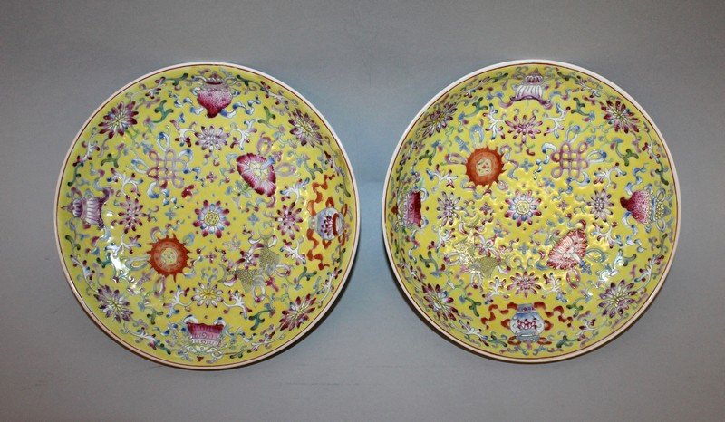 A PAIR OF CHINESE FAMILLE ROSE YELLOW GROUND PORCELAIN: A PAIR OF CHINESE FAMILLE ROSE YELLOW GROUND PORCELAIN DISHES, each decorated with the Eight Buddhist Emblems, each base with a Jiaqing seal mark, 7.7in diameter.