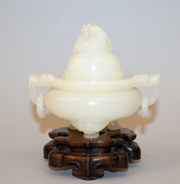 A CHINESE JADE-LIKE TRIPOD CENSER & COVER, together: A CHINESE JADE-LIKE TRIPOD CENSER & COVER, together with a fitted wood stand, the sides with double dragon-head and loose ring handles, the cover with a dragon finial, the censer itself 4.5in high ove