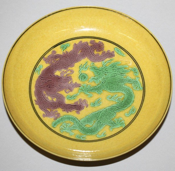A CHINESE YELLOW-GROUND DRAGON & PHOENIX PORCELAIN: A CHINESE YELLOW-GROUND DRAGON & PHOENIX PORCELAIN DISH, the interior decorated in green and aubergine with two confronting dragons, the base with a six-character Guangxu mark, 5.1in diameter.