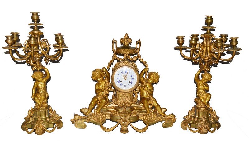 A VERY GOOD LARGE 19TH CENTURY FRENCH ORMOLU THREE: A VERY GOOD LARGE 19TH CENTURY FRENCH ORMOLU THREE PIECE GARNITURE comprising clock and pair of seven light candelabra with eight day movement, blue and white Roman numerals in a case with three cupid