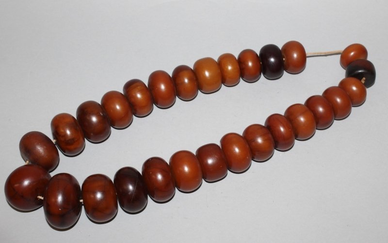 AN AMBER-STYLE NECKLACE, composed of large graduated (1 of 4)