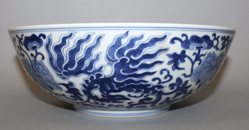 A CHINESE BLUE & WHITE PORCELAIN PHOENIX BOWL,: A CHINESE BLUE & WHITE PORCELAIN PHOENIX BOWL, decorated with a formal design of phoenix amidst scroll-stemmed foliage, the base with a Qianlong seal mark, 9.4in diameter & 3.4in high.