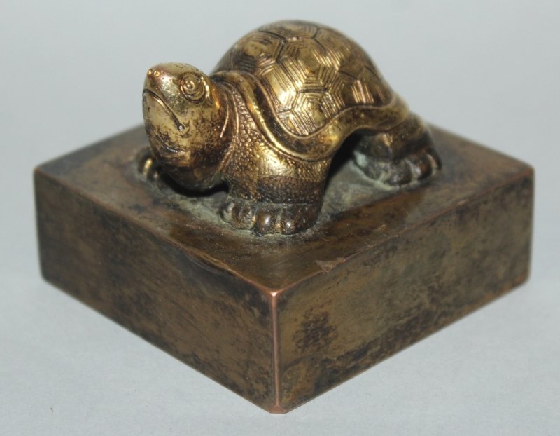 A CHINESE SQUARE-SECTION GILT BRONZE SEAL, surmounted (1 of 3)
