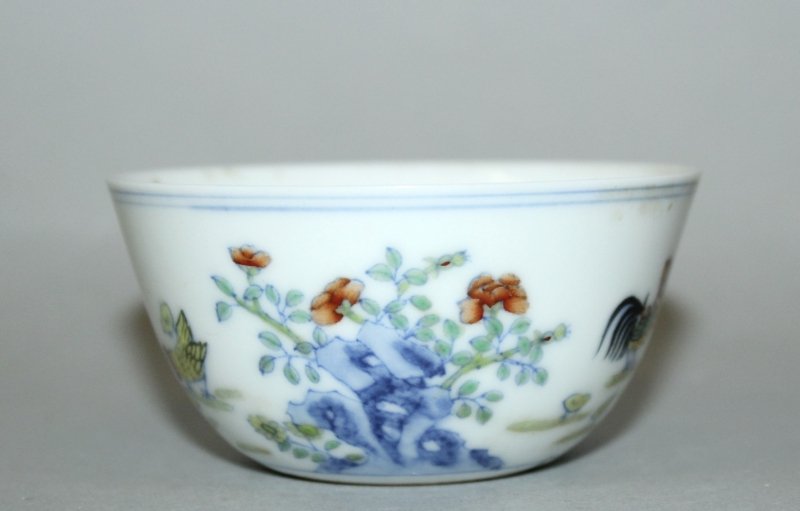 A CHINESE PORCELAIN CHICKEN CUP, the sides decorated: A CHINESE PORCELAIN CHICKEN CUP, the sides decorated with cockerels, hens and chicks in a garden setting of rockwork and foliage, the base with a six-character Yongzheng mark, 3.1in diameter & 1.5in h