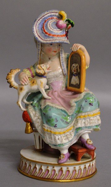 A GOOD SMALL MEISSEN FIGURE GROUP OF A YOUNG LADY: A GOOD SMALL MEISSEN FIGURE GROUP OF A YOUNG LADY sitting on a stool, a dog on her lap with reflection in the mirror, on circular base. 5.5ins high.Cross swords mark in blue. Incised No. F50.