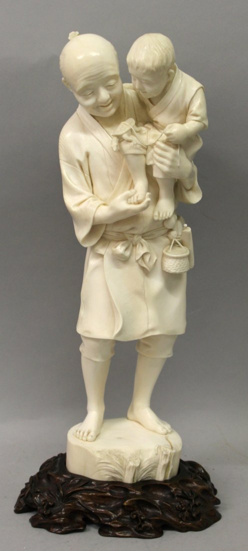 A LARGE FINE QUALITY SIGNED JAPANESE MEIJI PERIOD TOKYO: A LARGE FINE QUALITY SIGNED JAPANESE MEIJI PERIOD TOKYO SCHOOL IVORY OKIMONO OF A MAN HOLDING A CHILD, together with a good quality fitted carved hardwood stand, the man and boy both looking down at a