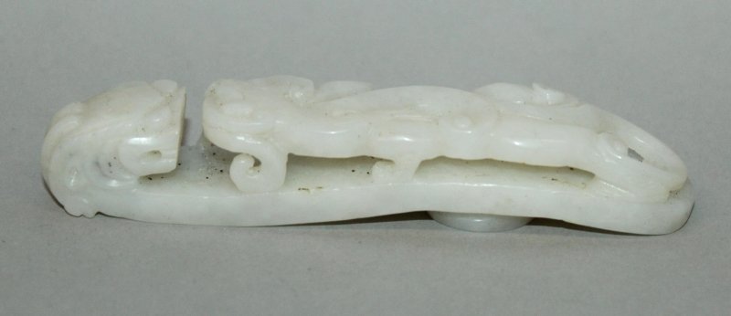 A CHINESE WHITE JADE-LIKE BELT HOOK, the stem pierced: A CHINESE WHITE JADE-LIKE BELT HOOK, the stem pierced with a chilong, the hook in the form of a dragon’s head, 4.6in long. £150-250