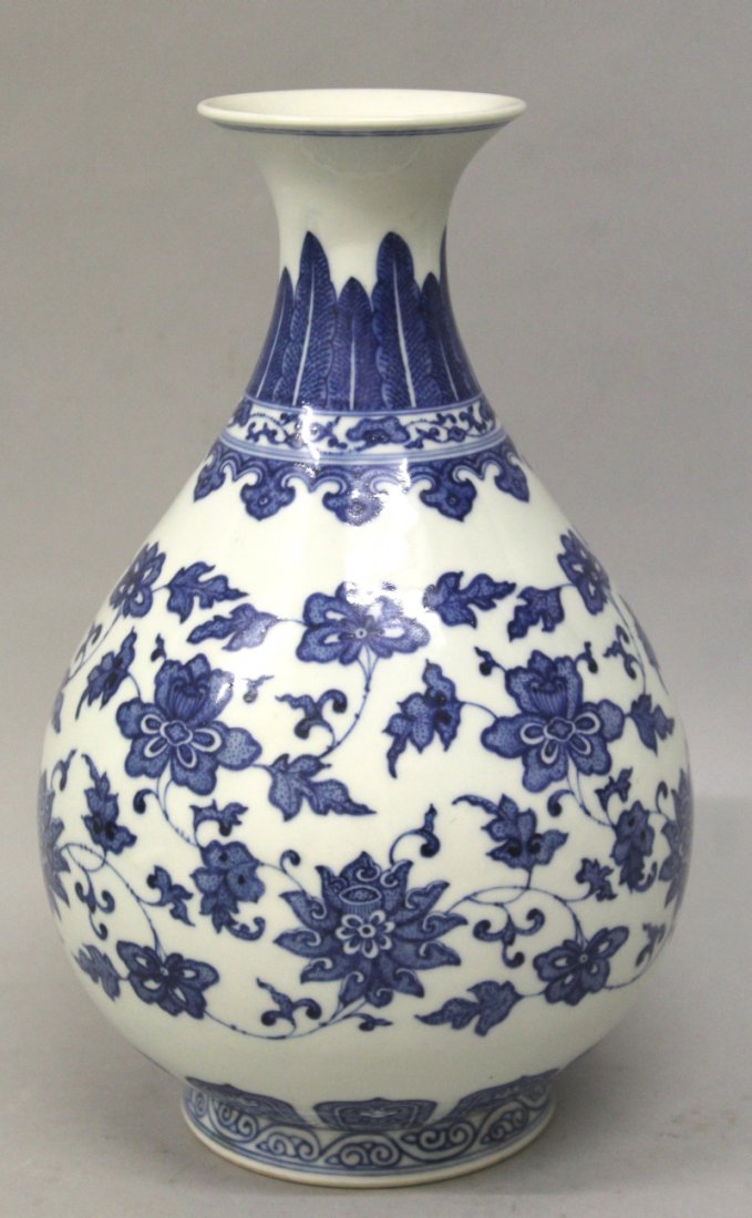 A GOOD QUALITY CHINESE BLUE & WHITE PORCELAIN VASE, the: A GOOD QUALITY CHINESE BLUE & WHITE PORCELAIN VASE, the sides of the pear-form body decorated in a retrospective style with formal scrolling foliage, the base with a Qianlong seal mark, 11in high. £3