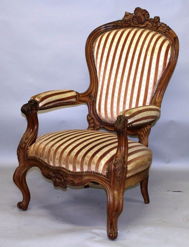 A VICTORIAN ARMCHAIR IN THE FRENCH TASTE, with carved: A VICTORIAN ARMCHAIR IN THE FRENCH TASTE, with carved show wood frame, pink striped upholstered back, arms and seat on cabriole legs. £200-300