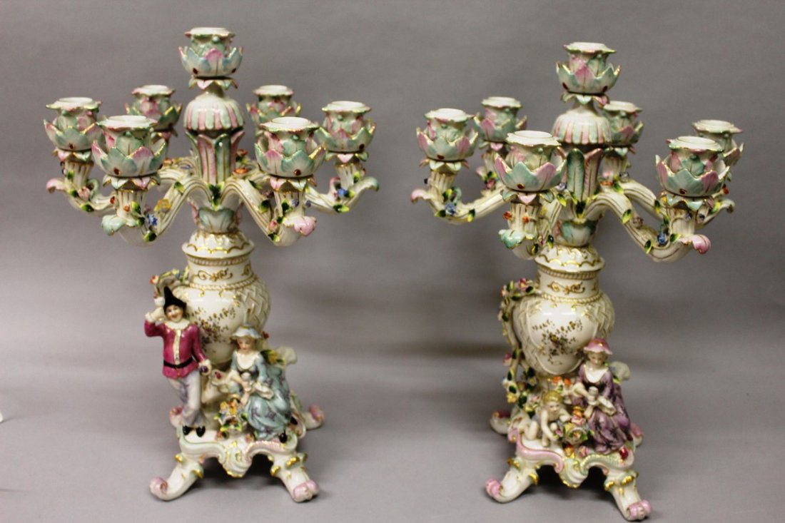 A GOOD PAIR OF DRESDEN DESIGN SEVEN LIGHT CANDELABRA: A GOOD PAIR OF DRESDEN DESIGN SEVEN LIGHT CANDELABRA with six scrolling branches encrusted with flowers, the bases with a young man and girl and supported on curving legs. 20ins high. £250-300