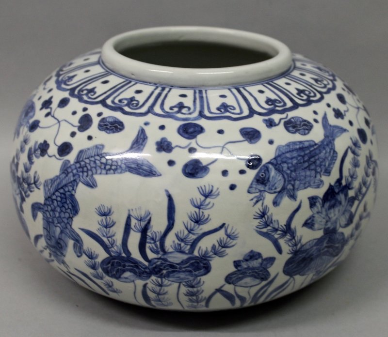 A CHINESE BLUE & WHITE PORCELAIN JAR, the sides of the: A CHINESE BLUE & WHITE PORCELAIN JAR, the sides of the squat ovoid body decorated with fish amidst water weeds, 10.3in wide at widest point & 6.4in high.