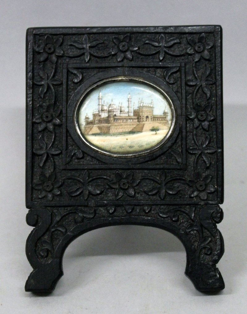 A SMALLER 19TH CENTURY INDIAN MINIATURE PAINTING ON: A SMALLER 19TH CENTURY INDIAN MINIATURE PAINTING ON IVORY, depicting the exterior of the Red Fort in Delhi, mounted in a carved wood display frame, the frame 3.1in wide x 4.1in high. John Nicholsons A