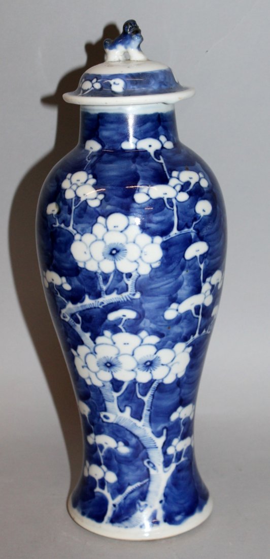 A 19TH CENTURY CHINESE BLUE & WHITE PORCELAIN VASE &: A 19TH CENTURY CHINESE BLUE & WHITE PORCELAIN VASE & COVER, the sides painted with prunus blossom reserved in white against a blue-wash crackled-ice ground, 12.25in high.