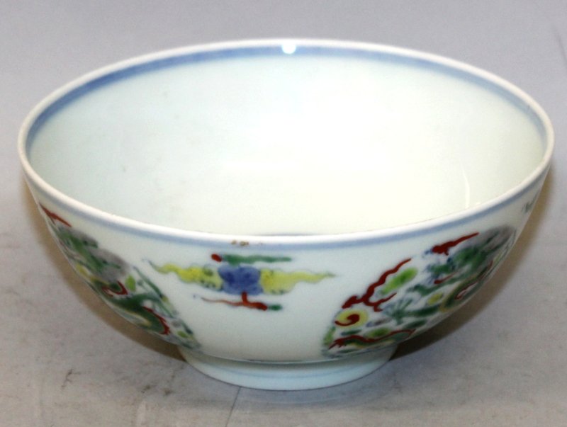 A CHINESE DOUCAI PORCELAIN BOWL, the sides decorated: A CHINESE DOUCAI PORCELAIN BOWL, the sides decorated with repeated dragon roundels, the base with a six-character Yongzheng mark, 5.1in diameter & 2.25in high.