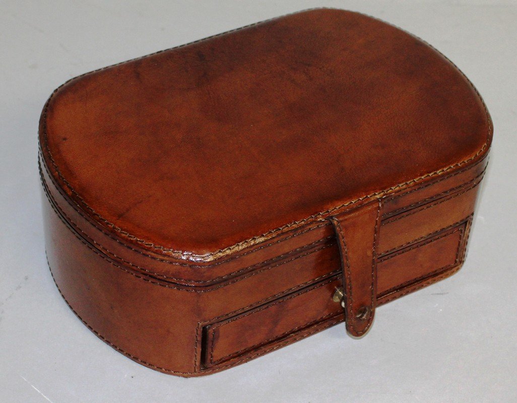 A GOOD LEATHER JEWELLERY BOX with rounded ends, fitted: A GOOD LEATHER JEWELLERY BOX with rounded ends, fitted interior and magnetic clasp. 10ins wide.