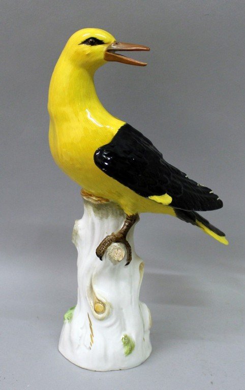 A GOOD 19TH CENTURY MEISSEN GOLDEN ORIOLE in yellow and: A GOOD 19TH CENTURY MEISSEN GOLDEN ORIOLE in yellow and black, standing on a tree stump. 10ins high. Cross swords mark in blue.
