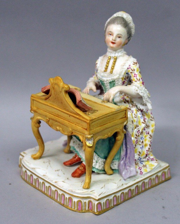 A 19TH CENTURY MEISSEN FIGURE OF A WOMAN playing a: A 19TH CENTURY MEISSEN FIGURE OF A WOMAN playing a piano. 5ins high. Cross swords mark in blue.
