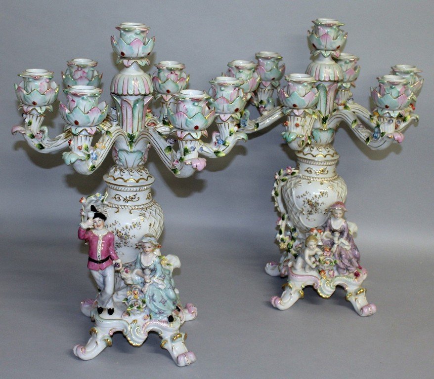 A LARGE PAIR OF "DRESDEN" SEVEN LIGHT CANDELABRA, the: A LARGE PAIR OF "DRESDEN" SEVEN LIGHT CANDELABRA, the base with a man and young lady holding cups of wine. 1ft 8ins high.