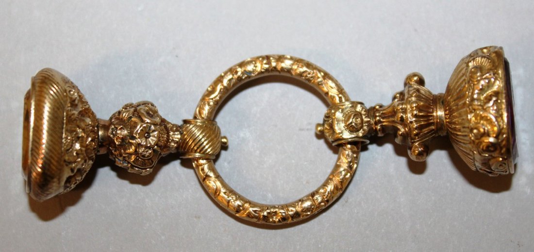 TWO GOLD SEALS ON A RING, one with citrine intaglio of: TWO GOLD SEALS ON A RING, one with citrine intaglio of a tree and a motto, the other with amethyst intaglio of a dragon with initials.