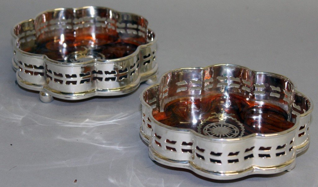 A PAIR OF CIRCULAR SHAPED TORTOISESHELL WINE COASTERS: A PAIR OF CIRCULAR SHAPED TORTOISESHELL WINE COASTERS on ball feet.