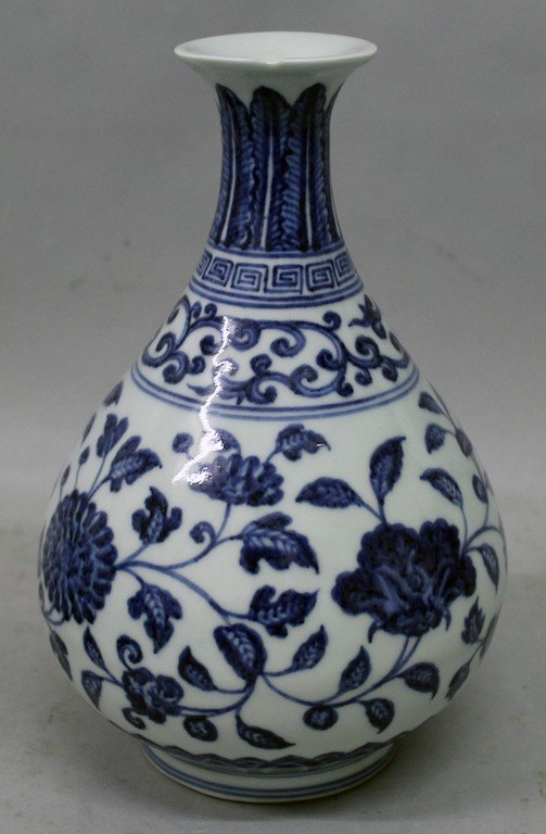 A CHINESE MING STYLE BLUE & WHITE PORCELAIN VASE, the: A CHINESE MING STYLE BLUE & WHITE PORCELAIN VASE, the sides of the pear-form body decorated with formal scroll-stemmed foliage, the base unglazed, 9.25in high.