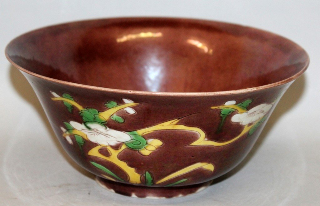 A 17TH/18TH CENTURY CHINESE KANGXI PERIOD BRINJAL BOWL,: A 17TH/18TH CENTURY CHINESE KANGXI PERIOD BRINJAL BOWL, circa 1700, the flaring sides decorated in white, green and yellow, with floral sprays reserved on an aubergine ground, the base with a â€˜s