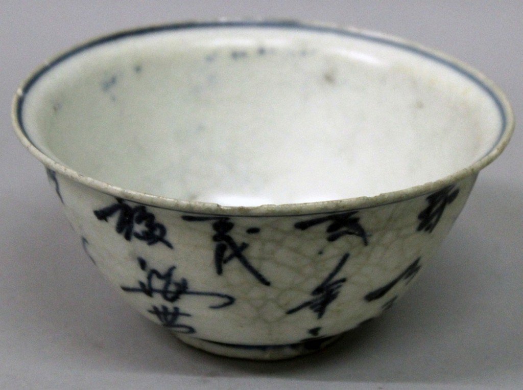 AN UNUSUAL 16TH/17TH CENTURY CHINESE BLUE & WHITE: AN UNUSUAL 16TH/17TH CENTURY CHINESE BLUE & WHITE SHIPWRECK PORCELAIN BOWL, the flaring sides painted with columns of calligraphy, 4.6in diameter & 2.3in high.