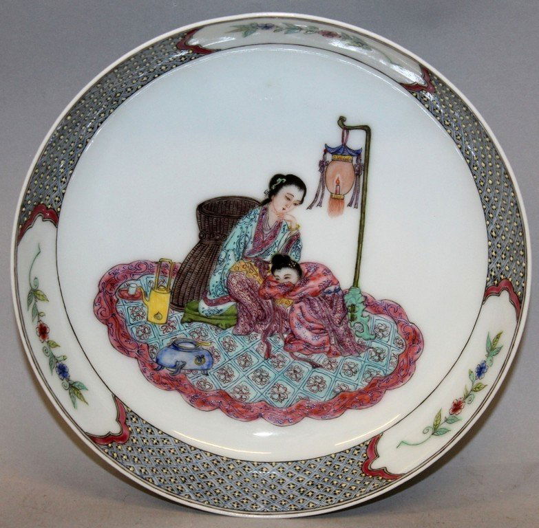 A FINE QUALITY CHINESE FAMILLE ROSE PORCELAIN SAUCER: A FINE QUALITY CHINESE FAMILLE ROSE PORCELAIN SAUCER DISH, the interior centre well painted with an scene of two ladies resting on a rug beside a hanging lantern, the interior rim with floral vignette