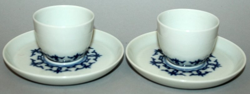 A PAIR OF CHINESE BLUE & WHITE PORCELAIN CUPS &: A PAIR OF CHINESE BLUE & WHITE PORCELAIN CUPS & SAUCERS, each piece decorated with a formal linked design, each base with a four-character Kangxi mark, the cups 2in diameter & 1.5in high, the saucers 