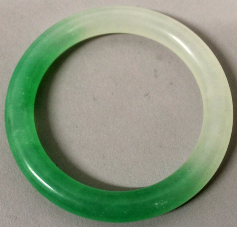 A CHINESE JADE BANGLE, the stone of white and of (1 of 2)