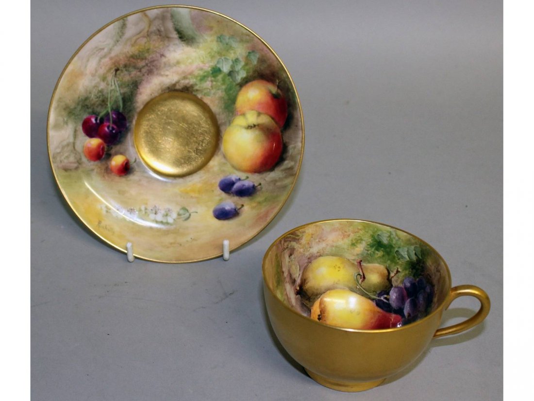 A Royal Worcester fruit painted teacup and saucer, both: A Royal Worcester fruit painted teacup and saucer, both signed by Ricketts, puce mark.