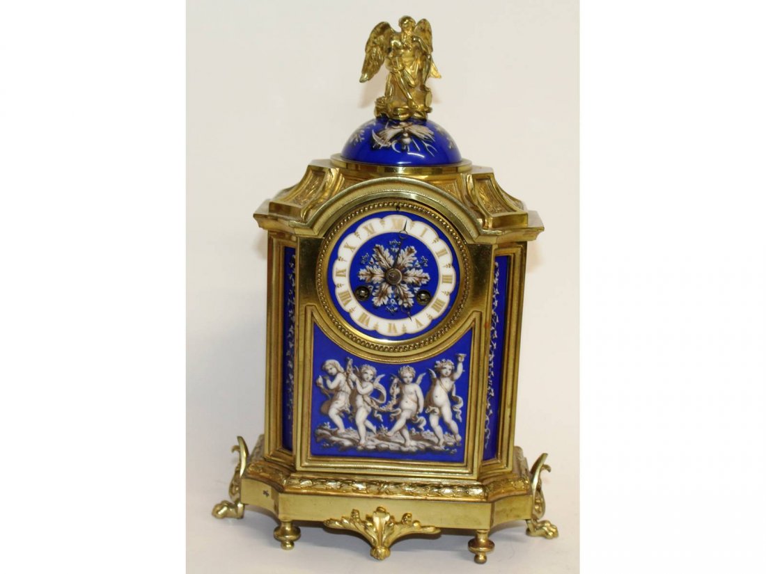 A superb 19th century French ormolu and porcelain: A superb 19th century French ormolu and porcelain clock, with Old Father Time finial, blue and white porcelain panels with cupids, musical trophies etc, with eight day movement striking on a single be