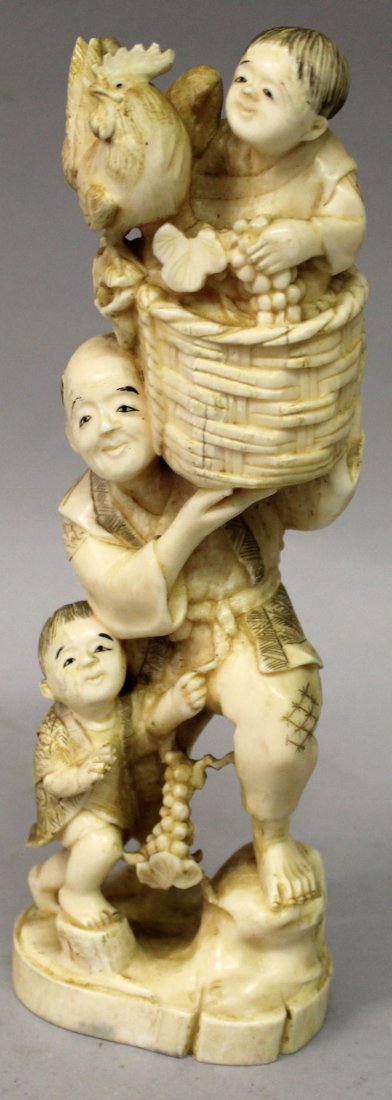 A SIGNED JAPANESE MEIJI PERIOD IVORY OKIMONO OF A GRAPE: A SIGNED JAPANESE MEIJI PERIOD IVORY OKIMONO OF A GRAPE HARVESTER, in the company of two boys and holding aloft a basket of grapes upon which sits one of the boys and a rooster, the base with an engra