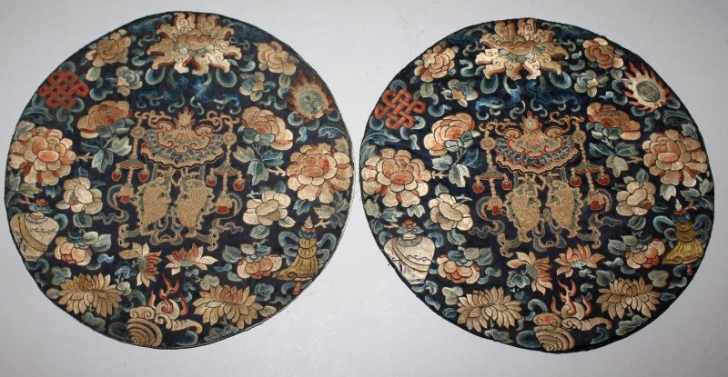 A GOOD PAIR OF 19TH CENTURY CHINESE EMBROIDERED SILK: A GOOD PAIR OF 19TH CENTURY CHINESE EMBROIDERED SILK ROUNDELS, one mounted on board, each decorated in satin and knot stitching with foliage and ribboned Buddhist emblems reserved on a black ground, e