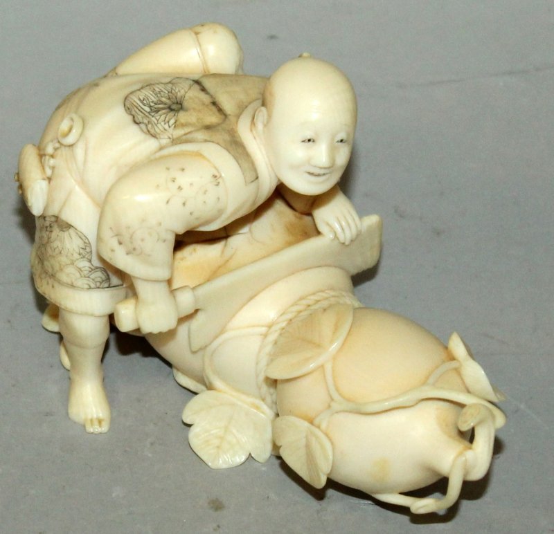A GOOD QUALITY SIGNED JAPANESE MEIJI PERIOD IVORY: A GOOD QUALITY SIGNED JAPANESE MEIJI PERIOD IVORY OKIMONO OF A MAN SAWING A GIANT GOURD, the man leaning over it with a large saw, his face with a cheerful expression, the base with an engraved signat