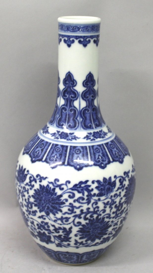 A GOOD QUALITY CHINESE BLUE & WHITE MING STYLE: A GOOD QUALITY CHINESE BLUE & WHITE MING STYLE PORCELAIN BOTTLE VASE, the sides decorated between formal borders with a formal band of scrolling lotus, the base with a Qianlong seal mark, 12in high.